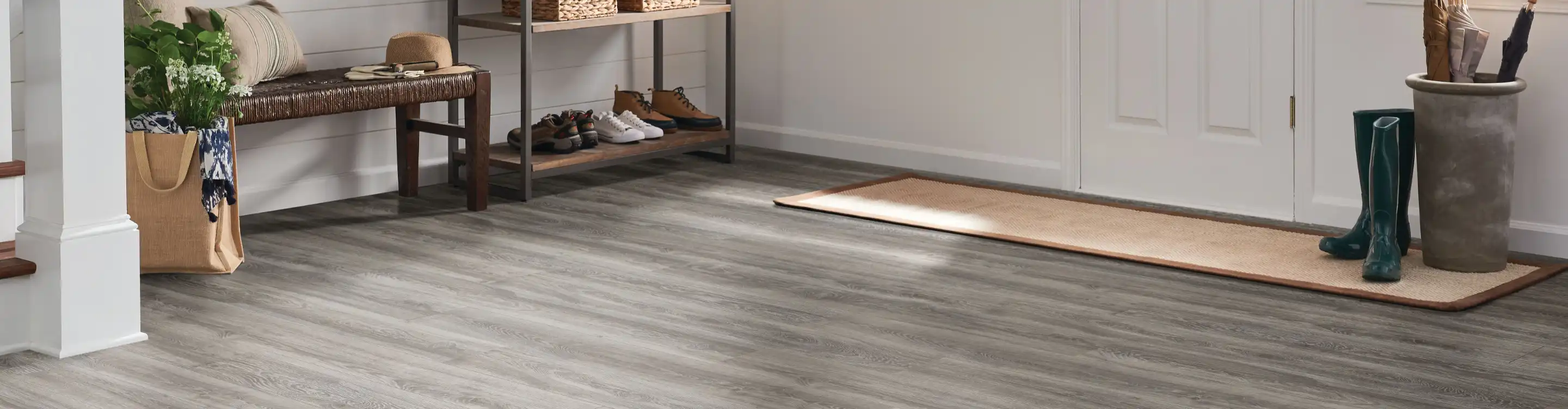 wood look laminate flooring in living room with grey couches